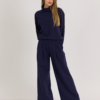 Woman with blond hair wearing organic cotton dark blue color blouse and dark blue color long wide pants