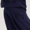 Woman with blond hair wearing organic cotton dark blue color blouse and dark blue color long wide pants