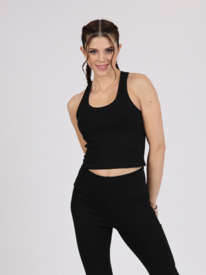Women with brown hair is wearing black organic cotton tank top and black organic cotton leggings