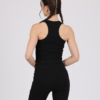 Women with brown hair is wearing black organic cotton tank top and black organic cotton leggings