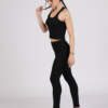 Women with brown hair is wearing black organic cotton tank top and black organic cotton leggings