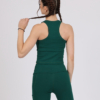 Women with brown hair is wearing dark green organic cotton tank top and dark green organic cotton leggings