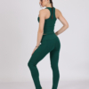 Women with brown hair is wearing dark green organic cotton tank top and dark green organic cotton leggings