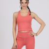 Women with brown hair is wearing pink organic cotton tank top and pink organic cotton leggings