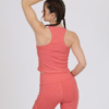 Women with brown hair is wearing pink organic cotton tank top and pink organic cotton leggings