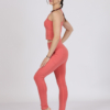 Women with brown hair is wearing pink organic cotton tank top and pink organic cotton leggings