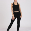 Women with brown hair is wearing black organic cotton tank top and black organic cotton leggings