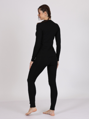 Women with brown hair is wearing black organic cotton long sleeve top and black organic cotton leggings