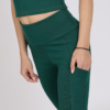 Women with brown hair is wearing dark green organic cotton tank top and dark green organic cotton leggings