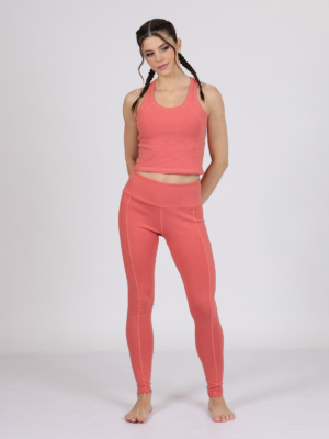 Women with brown hair is wearing pink organic cotton tank top and pink organic cotton leggings