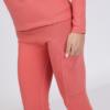 Women with brown hair is wearing pink organic cotton long sleeve top and pink organic cotton leggings