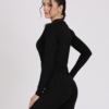 Women with brown hair is wearing black organic cotton long sleeve top and black organic cotton leggings