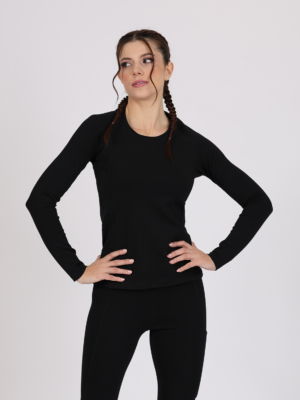 Women with brown hair is wearing black organic cotton long sleeve top and black organic cotton leggings