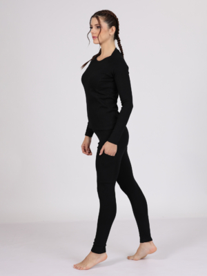 Women with brown hair is wearing black organic cotton long sleeve top and black organic cotton leggings