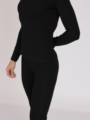 Women with brown hair is wearing black organic cotton long sleeve top and black organic cotton leggings