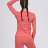 Women with brown hair is wearing pink organic cotton long sleeve top and pink organic cotton leggings