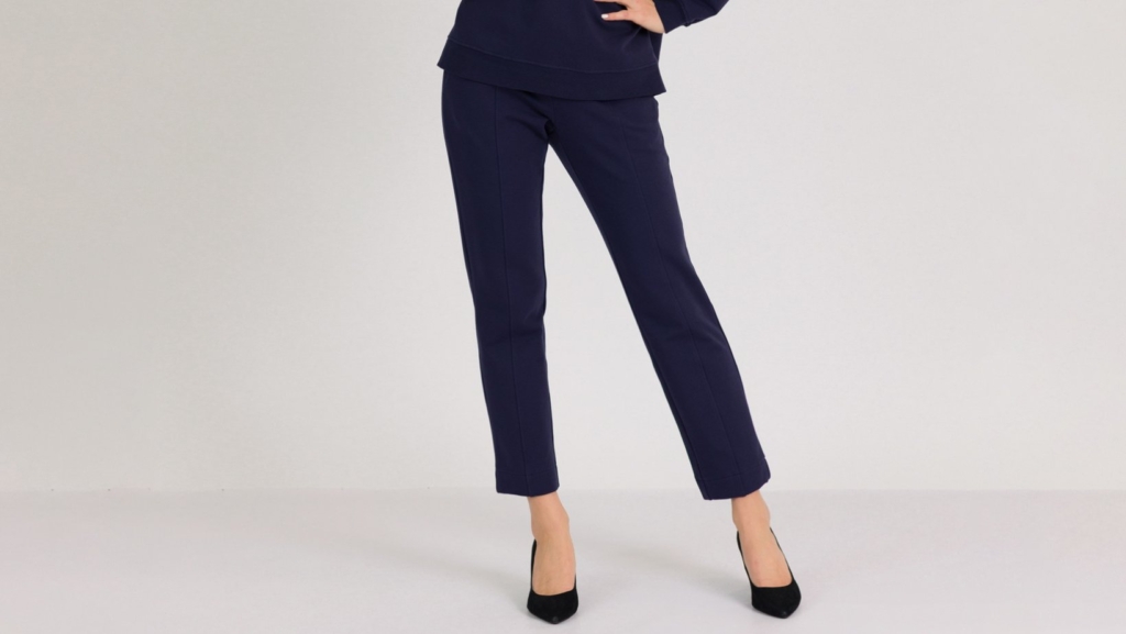 woman wearing dark blue organic cotton oversized polo collar sweatshirt and dark blue organic cotton long tapered leg pants