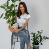 Woman wearing organic cotton jeans and white organic cotton t-shirt with embroidery "proud outfit reperater