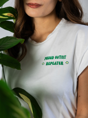 Woman wearing white organic cotton t-shirt with embroidery "proud outfit reperater