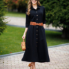 Woman wearing black organic cotton shirt dress with bracelet sleeves coconut buttons and waist belt