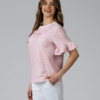 Woman wearing white organic cotton pants and pink striped organic cotton t-shirt with embroidery "Less is more"