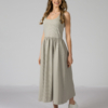 Woman wearing gray organic cotton dress with a flared skirt, midi length, square neckline, high waist and pockets.