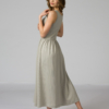 Woman wearing gray organic cotton dress with a flared skirt, midi length, square neckline, high waist and pockets.