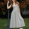 Woman wearing gray organic cotton dress with a flared skirt, midi length, square neckline, high waist and pockets.