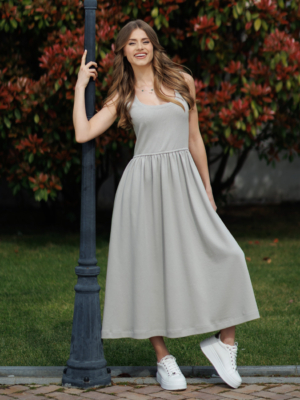 Woman wearing gray organic cotton dress with a flared skirt, midi length, square neckline, high waist and pockets.