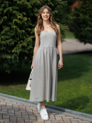 Woman wearing gray organic cotton dress with a flared skirt, midi length, square neckline, high waist and pockets.