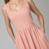 Woman wearing pink organic cotton dress with a flared skirt, midi length, square neckline, high waist and pockets.