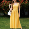Woman wearing yellow organic cotton dress with a flared skirt, midi length, square neckline, high waist and pockets.