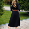 Woman wearing black organic cotton shirt dress with bracelet sleeves coconut buttons and waist belt