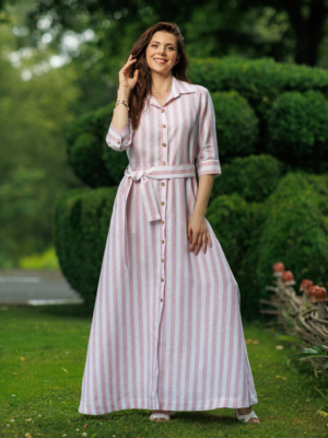 Dark-haired woman wearing a long pink striped linen dress with coconut buttons and collar