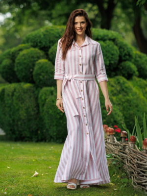 Dark-haired woman wearing a long pink striped linen dress with coconut buttons and collar