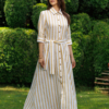 Dark-haired woman wearing a long linen dress with coconut buttons and collar