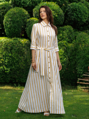 Dark-haired woman wearing a long linen dress with coconut buttons and collar