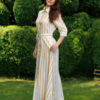 Dark-haired woman wearing a long linen dress with coconut buttons and collar