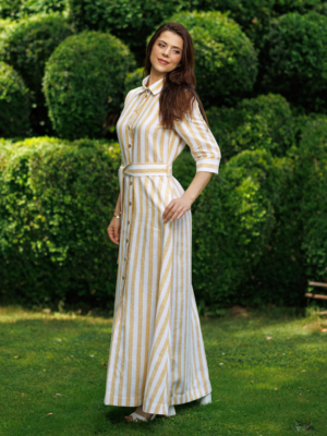Dark-haired woman wearing a long linen dress with coconut buttons and collar
