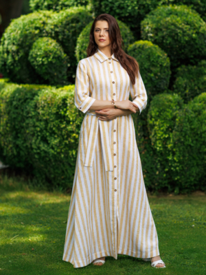 Dark-haired woman wearing a long linen dress with coconut buttons and collar