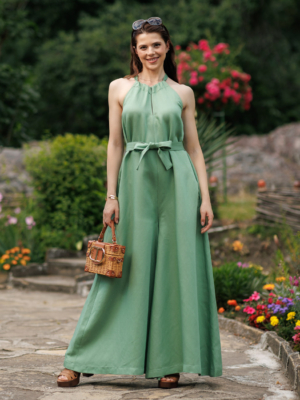Dark-haired woman wearing a green jumpsuit with wide legs made of lyocell and linen