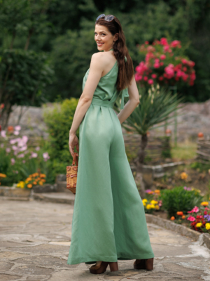 Dark-haired woman wearing a green jumpsuit with wide legs made of lyocell and linen