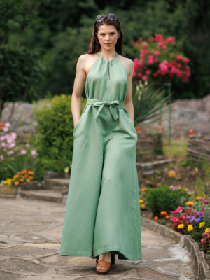 Dark-haired woman wearing a green jumpsuit with wide legs made of lyocell and linen