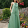 Dark-haired woman wearing a green jumpsuit with wide legs made of lyocell and linen