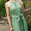Dark-haired woman wearing a green jumpsuit with wide legs made of lyocell and linen
