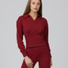 Тъмночервена дамска блуза с яка, паднали рамене, широки ръкави с маншети и вталена талия, изработена от органичен памук и тъмночервен дамски панталон с висока талия и кройка тип jogger, със скосени крачоли с маншет, странични джобове и декоративен шев.“